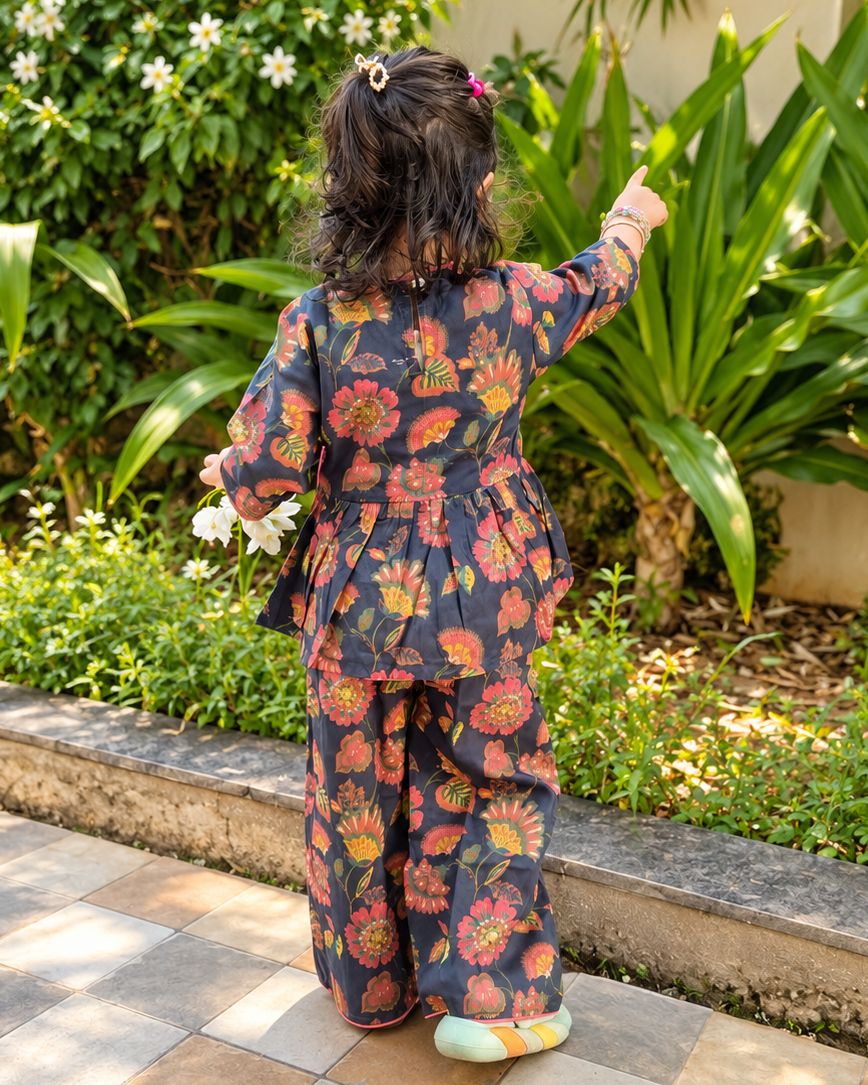 A young child viewed from behind wearing a dark navy floral Angrakha top with matching pant from Aruvo.