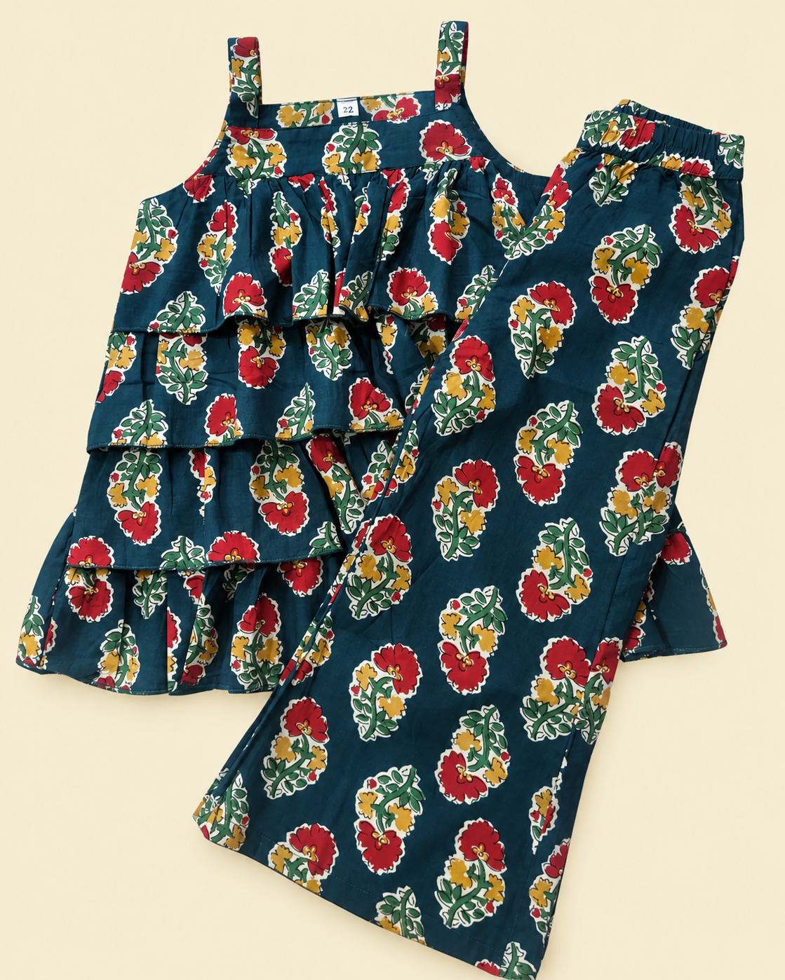 A two-piece girls' outfit set featuring a sleeveless ruffled top and matching wide-leg pants, both in a dark teal blue floral print with red, yellow, and green flowers.