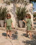 A cute girl wearing SnugBug's striped pure cotton stylish shorts set and standing near an open area 